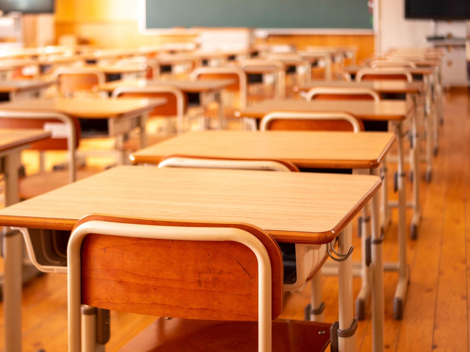 Fachada moderna de uma Escola Estadual com alunos entrando e saindo no horário escolar.